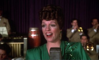 Movie still from “New York, New York” (1977), directed by Martin Scorsese – A woman in a green dress is singing into a microphone; Close Up shot, Low angle