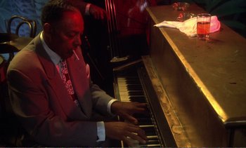 Movie still from “New York, New York” (1977), directed by Martin Scorsese – A man in a red suit playing a piano; Close Up shot, Low angle