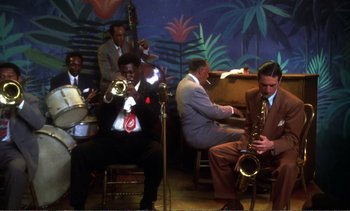 Movie still from “New York, New York” (1977), directed by Martin Scorsese – A group of men playing musical instruments in front of a mural; Extreme Wide shot, High angle