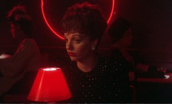 Movie still from “New York, New York” (1977), directed by Martin Scorsese – A woman sitting in front of a red lamp; Close Up shot, High angle