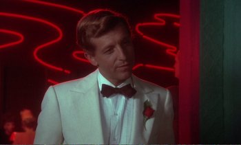 Movie still from “New York, New York” (1977), directed by Martin Scorsese – A man in a white suit with a rose in his lapel; Close Up shot, Over the shoulder angle