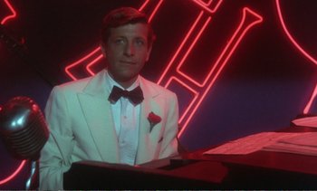 Movie still from “New York, New York” (1977), directed by Martin Scorsese – A man wearing a white suit and bow tie; Medium shot, Low angle