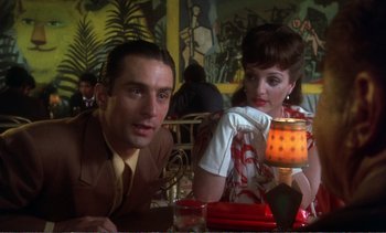 Movie still from “New York, New York” (1977), directed by Martin Scorsese – A man and a woman sitting at a table in a restaurant; Medium shot, Over the shoulder angle