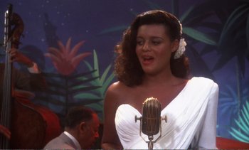 Movie still from “New York, New York” (1977), directed by Martin Scorsese – A woman in a white dress singing into a microphone; Medium shot, High angle