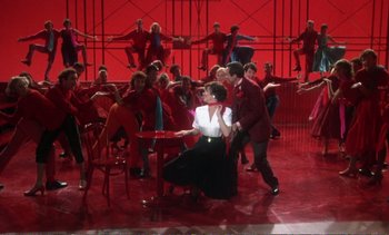 Movie still from “New York, New York” (1977), directed by Martin Scorsese – A group of people in a room with a red wall; Wide shot, High angle