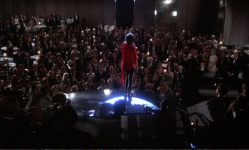 Movie still from “New York, New York” (1977), directed by Martin Scorsese – A crowd of people watching a man stand on a stage; Extreme Wide shot, High angle