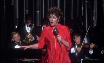 Movie still from “New York, New York” (1977), directed by Martin Scorsese – A woman in a red dress is holding a microphone; Medium shot, High angle