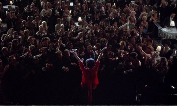 Movie still from “New York, New York” (1977), directed by Martin Scorsese – A woman in a red jacket is in front of a crowd; Extreme Wide shot, Overhead angle