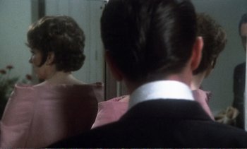 A man and a woman are looking in a mirror