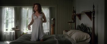 Movie still from “Gerald's Game” (2017), directed by Mike Flanagan – A woman in a nightgown standing on a bed in front of a window; Medium shot, High angle
