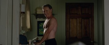Movie still from “Gerald's Game” (2017), directed by Mike Flanagan – A shirtless man standing in front of a towel rack; Medium shot, Over the shoulder angle