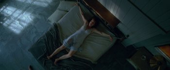 Movie still from “Gerald's Game” (2017), directed by Mike Flanagan – A woman laying on a bed in a room; Wide shot, Overhead angle
