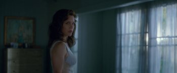 Movie still from “Gerald's Game” (2017), directed by Mike Flanagan – A woman standing in front of a window in a room; Medium shot, Over the shoulder angle