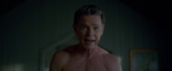 Movie still from “Gerald's Game” (2017), directed by Mike Flanagan – A shirtless man with no shirt in a dark room; Close Up shot, Over the shoulder angle