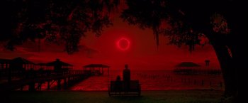Movie still from “Gerald's Game” (2017), directed by Mike Flanagan – Two people sitting on a bench watching a solar eclipse; Extreme Wide shot, High angle
