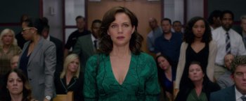 Movie still from “Gerald's Game” (2017), directed by Mike Flanagan – A woman in a green dress in front of a group of people; Medium shot, Over the shoulder angle