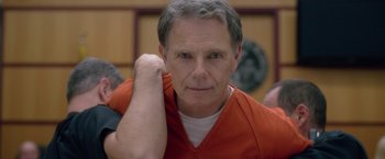 Movie still from “Gerald's Game” (2017), directed by Mike Flanagan – An older man in an orange shirt is posing for a picture; Close Up shot, Over the shoulder angle