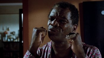 Movie still from “Next Friday” (2000), directed by Steve Carr – An older black man is holding his hands up to his face; Close Up shot, Low angle