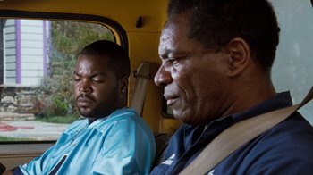 Movie still from “Next Friday” (2000), directed by Steve Carr – Two men sitting in the back seat of a vehicle; Close Up shot, Over the shoulder angle