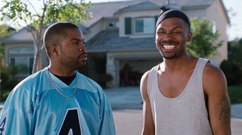 Movie still from “Next Friday” (2000), directed by Steve Carr – Two men standing next to each other in front of a house; Medium shot, Over the shoulder angle