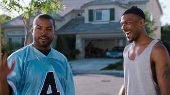Movie still from “Next Friday” (2000), directed by Steve Carr – Two men standing next to each other in front of a house; Medium shot, Over the shoulder angle