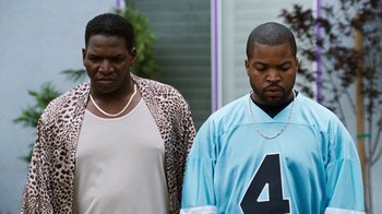 Movie still from “Next Friday” (2000), directed by Steve Carr – Two men standing next to each other on the sidewalk; Medium shot, Over the shoulder angle