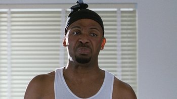 Movie still from “Next Friday” (2000), directed by Steve Carr – A person wearing a tank top and a bandana; Close Up shot, Low angle