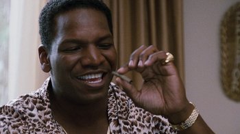 Movie still from “Next Friday” (2000), directed by Steve Carr – A man smiling while holding a cigarette in his mouth; Close Up shot, High angle
