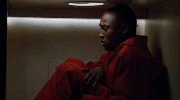 Movie still from “Next Friday” (2000), directed by Steve Carr – A man in a red suit sitting in a room; Close Up shot, Overhead angle