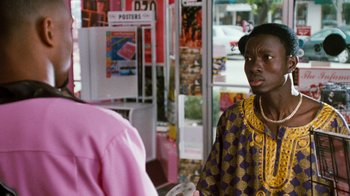 Movie still from “Next Friday” (2000), directed by Steve Carr – A man wearing a purple and yellow shirt is talking to a woman; Medium shot, Over the shoulder angle