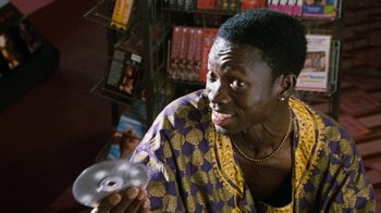 Movie still from “Next Friday” (2000), directed by Steve Carr – A woman holding a cd in her hand and looking at the camera; Close Up shot, High angle