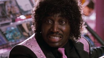 Movie still from “Next Friday” (2000), directed by Steve Carr – A person wearing a suit and tie; Close Up shot, Low angle