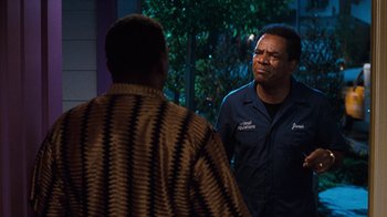 Movie still from “Next Friday” (2000), directed by Steve Carr – Two men standing next to each other in front of a window; Medium shot, Over the shoulder angle