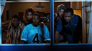 Movie still from “Next Friday” (2000), directed by Steve Carr – A group of people looking out of a window; Medium shot, High angle