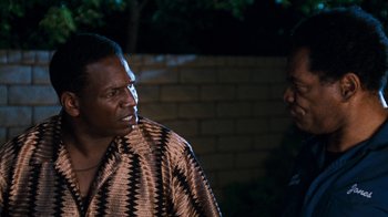 Movie still from “Next Friday” (2000), directed by Steve Carr – Two men standing next to each other near a brick wall; Close Up shot, Over the shoulder angle