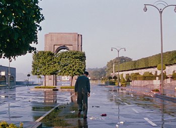Movie still from “Niagara” (1953), directed by Henry Hathaway – A man walking down a street in the rain; Extreme Wide shot, High angle