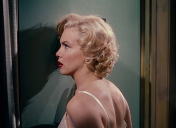 Movie still from “Niagara” (1953), directed by Henry Hathaway – A woman with blonde curly hair and red lipstick; Close Up shot, Over the shoulder angle