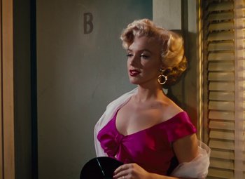 Movie still from “Niagara” (1953), directed by Henry Hathaway – A woman in a pink dress holding a black purse; Medium shot, High angle