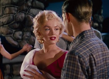 Movie still from “Niagara” (1953), directed by Henry Hathaway – A woman in a red dress talking to a man in a plaid shirt; Medium shot, Over the shoulder angle