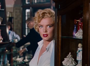 Movie still from “Niagara” (1953), directed by Henry Hathaway – A woman with blonde hair and red lipstick looking at the camera; Medium shot, Over the shoulder angle