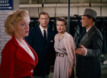 Movie still from “Niagara” (1953), directed by Henry Hathaway – A group of people standing next to each other in a room; Medium shot, Over the shoulder angle
