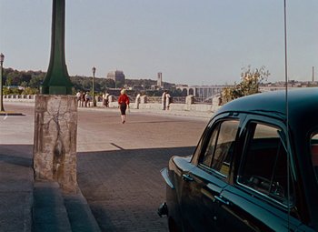 Movie still from “Niagara” (1953), directed by Henry Hathaway – A man running across the street from a car; Extreme Wide shot, High angle