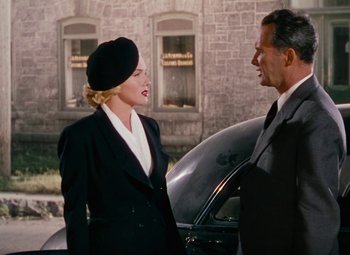 Movie still from “Niagara” (1953), directed by Henry Hathaway – A man and a woman standing next to each other in front of a car; Medium shot, Over the shoulder angle