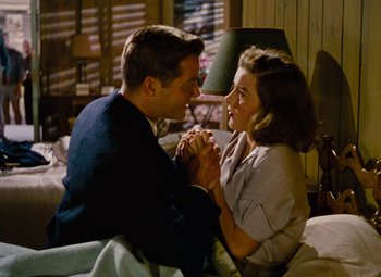 Movie still from “Niagara” (1953), directed by Henry Hathaway – A man and a woman sitting on a bed holding hands; Medium shot, High angle