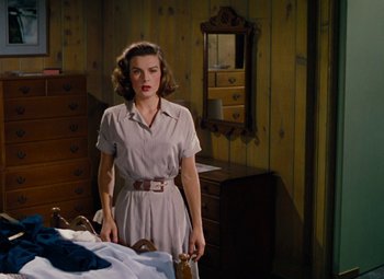 Movie still from “Niagara” (1953), directed by Henry Hathaway – A woman standing in front of a dresser in a room; Medium shot, High angle