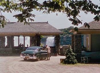 Movie still from “Niagara” (1953), directed by Henry Hathaway – An old car parked in front of a waterfall; Extreme Wide shot, Over the shoulder angle