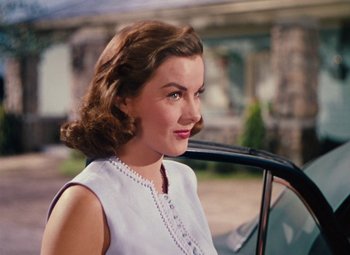 Movie still from “Niagara” (1953), directed by Henry Hathaway – A woman in a white dress sitting in the drivers seat of a car; Close Up shot, Over the shoulder angle