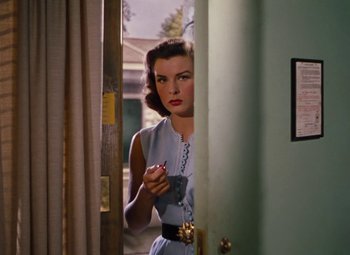 Movie still from “Niagara” (1953), directed by Henry Hathaway – A woman standing in front of a door holding a phone; Medium shot, Over the shoulder angle