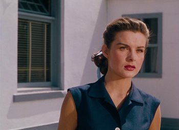 Movie still from “Niagara” (1953), directed by Henry Hathaway – A woman in a blue dress standing in front of a building; Close Up shot, Low angle