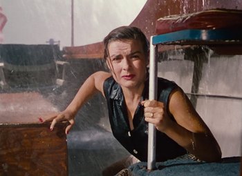 Movie still from “Niagara” (1953), directed by Henry Hathaway – A woman leaning on a railing in the pouring rain; Medium shot, High angle